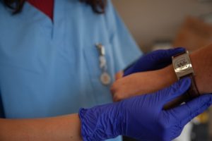 Travel nurse helping patient with medical ID bracelet