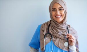 travel nurse in hijab smiling after joining travel nursing agency